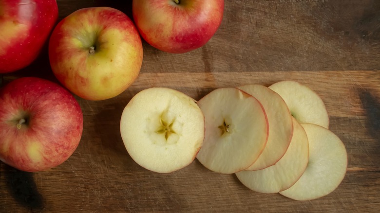 sliced apple rounds with whole apples