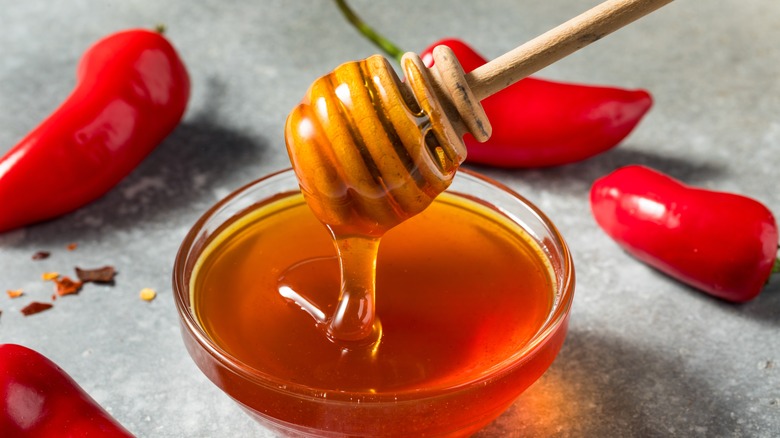 honey in a bowl surrounded by chilies