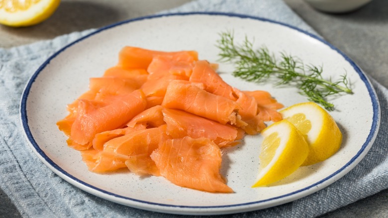 salmon lox platter with lemon slices and herbs