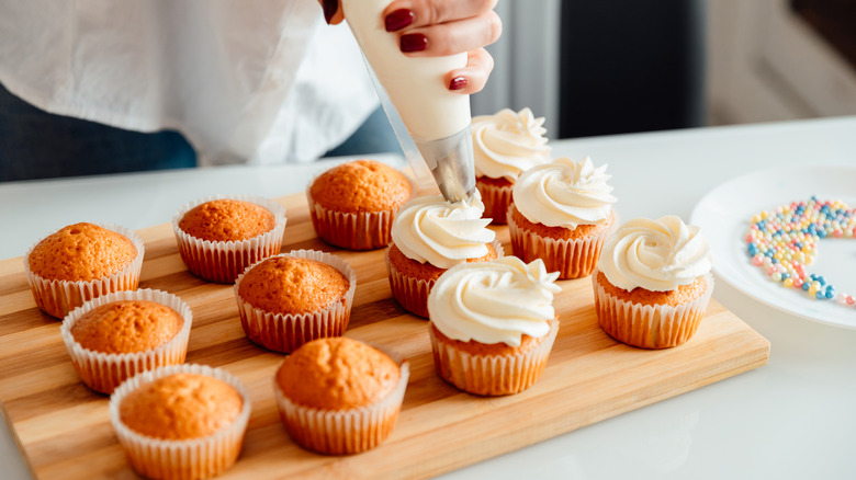 Hand frosting cupcakes