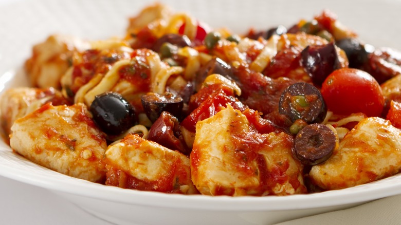 Close-up of pasta puttanesca with sliced Kalamata olives over tortellini