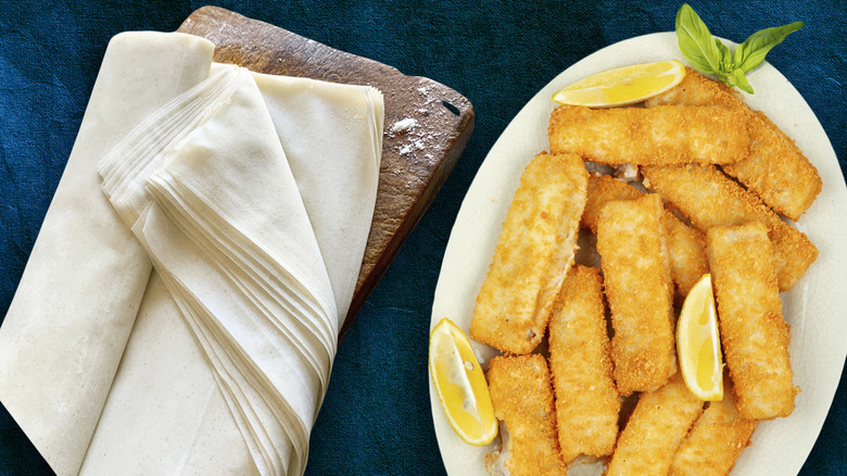 plate of fish sticks and phyllo dough on wood board