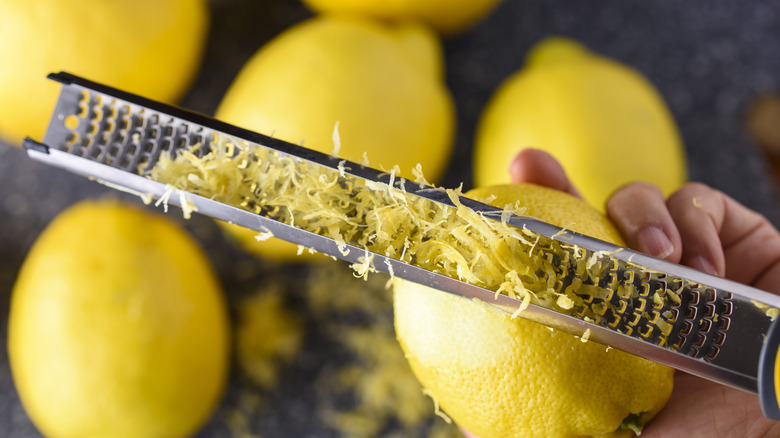 A lemon being zested with a grater
