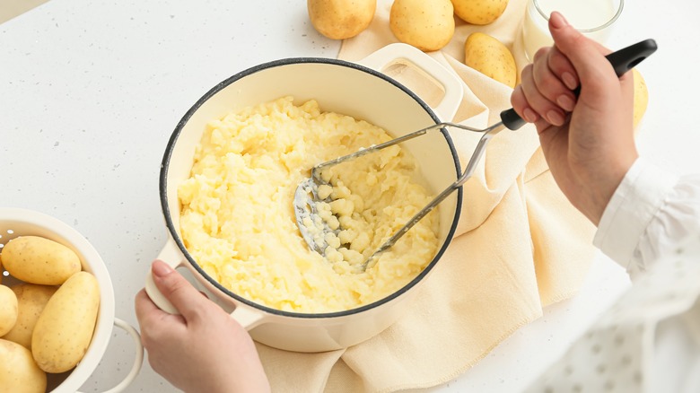 mashing potatoes in pot