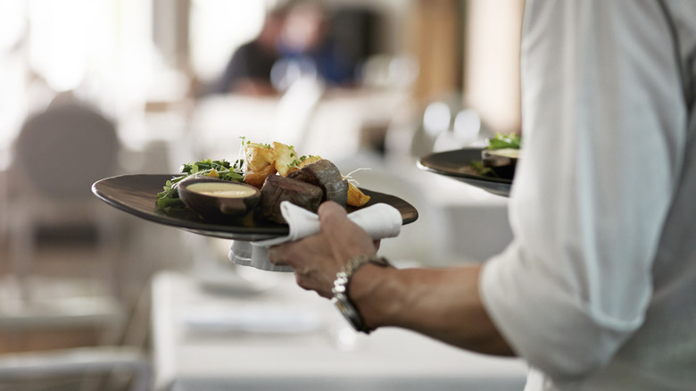 Server bringing out plates of food