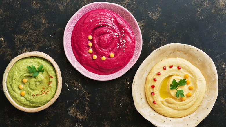 bowls of different kinds of hummus