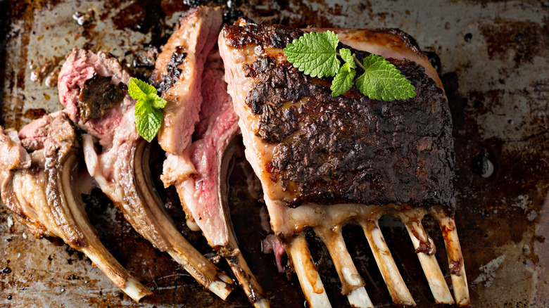 A cooked rack of lamb with some chops cut