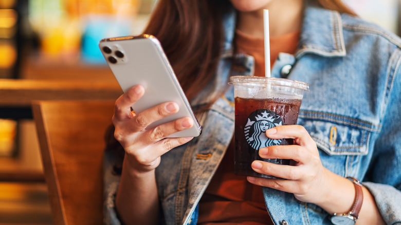 Holding drink and phone