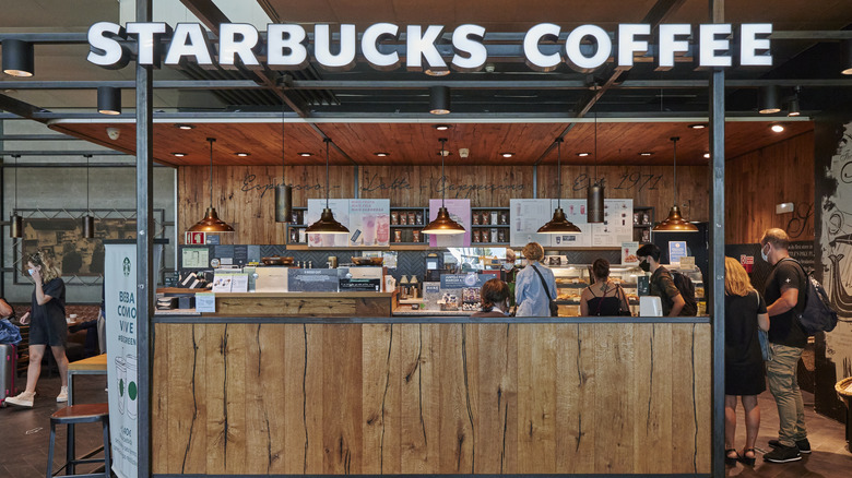 A Starbucks counter with a line of customers