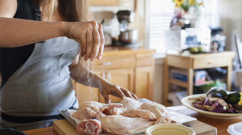 Hand seasoning raw chicken