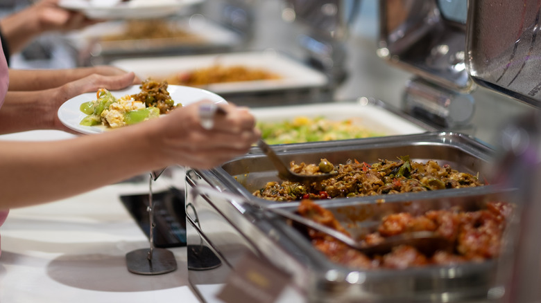 Person serving food at hot buffet