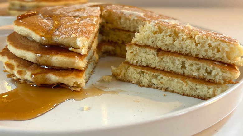 IHOP pancake stack cut open on white plate with butter and syrup