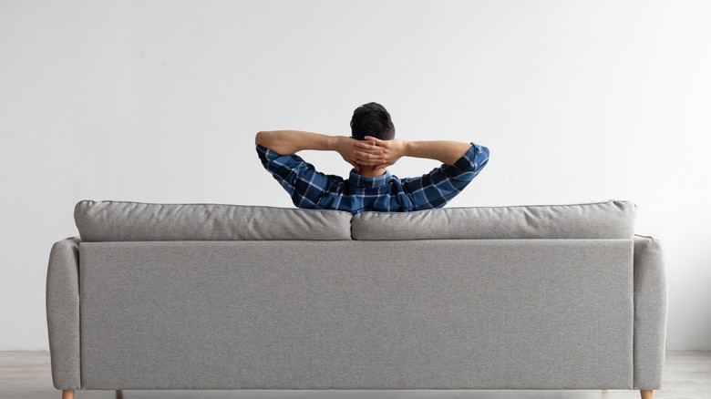 man relaxing on couch alone