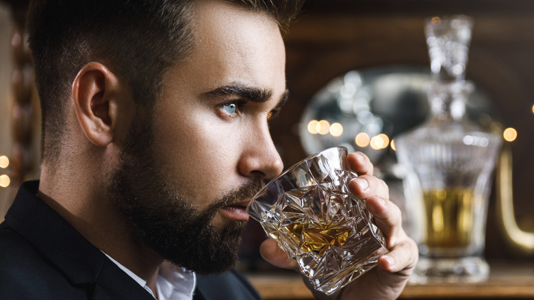 Bearded man sipping whiskey