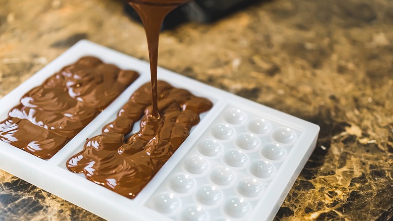 pouring chocolate into plastic mold