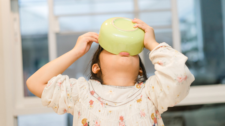 Girl eating from soup bowl