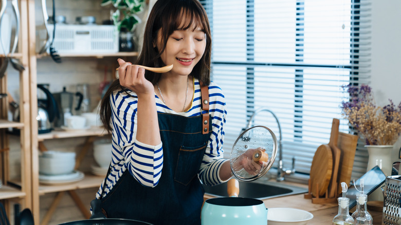 Home cook tasting from pot