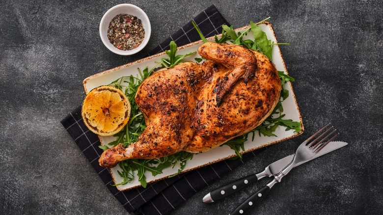 Half roasted chicken on arugula