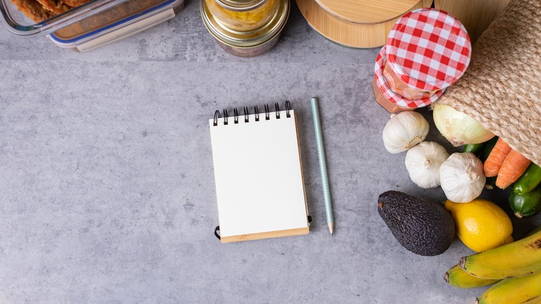 paper, pencil surrounded by food