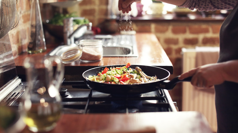 Salting food on the stove while cooking