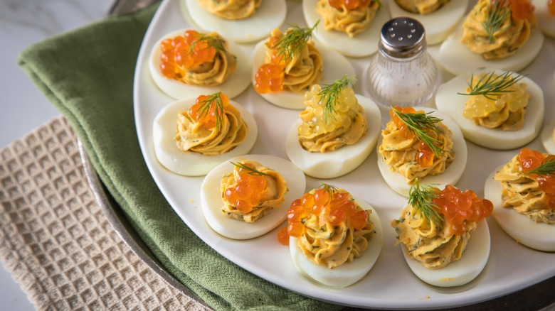 Plate of deviled eggs topped with salmon roe