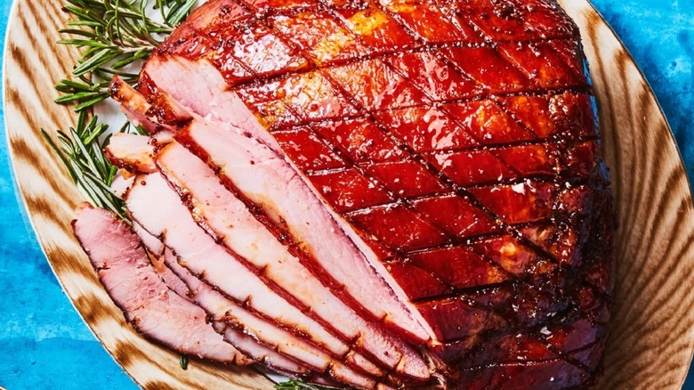 Top-down closeup of a sliced glazed ham on a plate