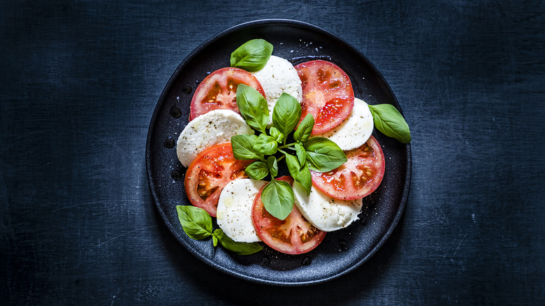 Caprese salad on black plate