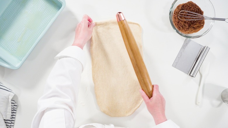 rolling pastry dough with rolling pin