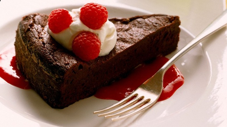 Chocolate cake slice plated on raspberry sauce