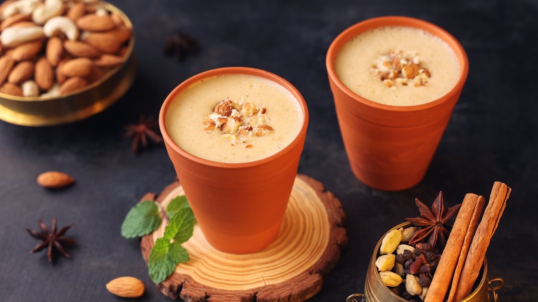 Two badam milk cups with almonds and spices