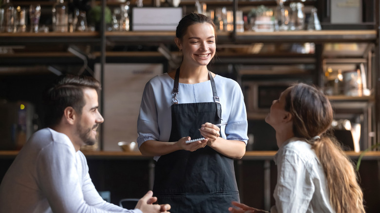 Diners giving their order to a server at a restaurant 