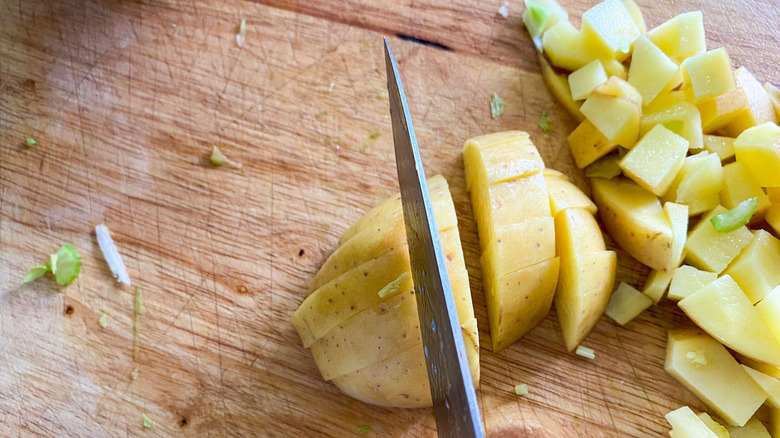 chopping potatoes on cutting board