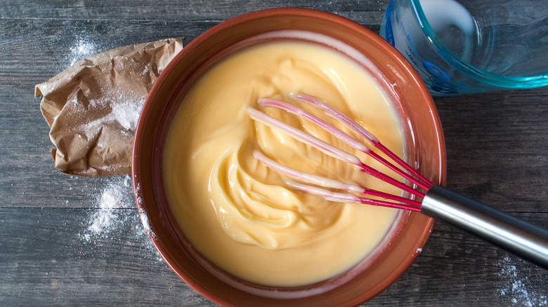 Vanilla pudding in a bowl with whisk 