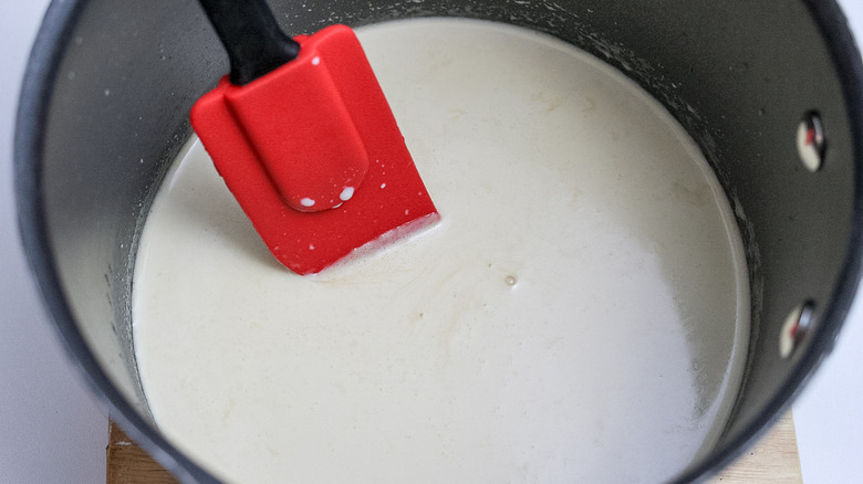 spatula mixing cream in saucepan