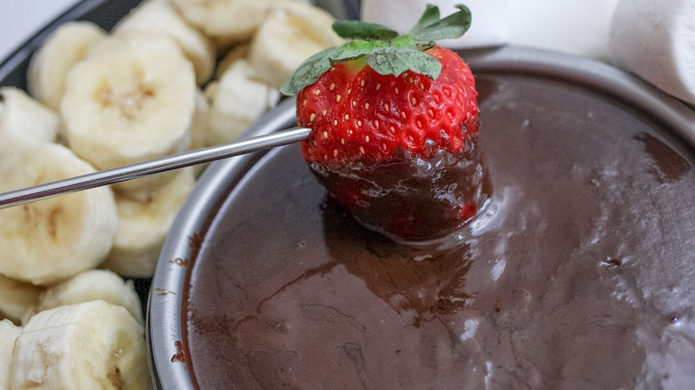 dipping strawberry in chocolate fondue