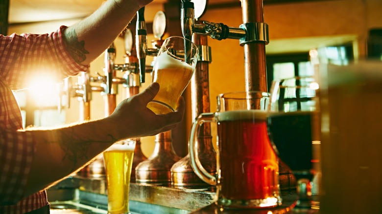 Bartender pouring draft beer in a pub