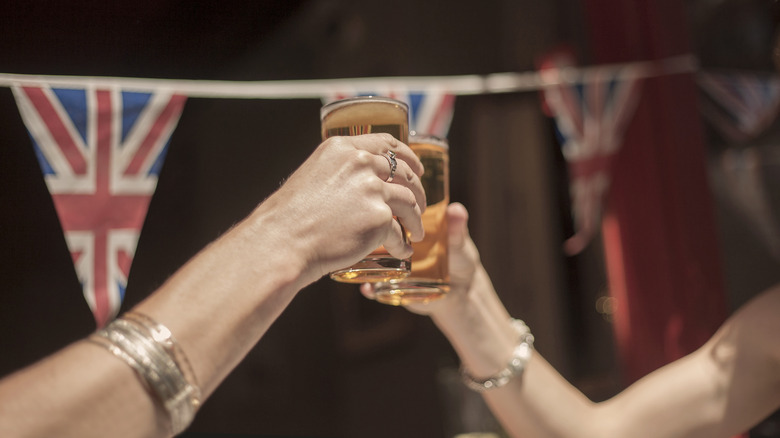 two people Cheersing glasses in an English pub