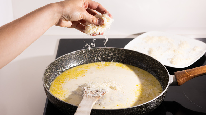 adding cheese to pasta sauce