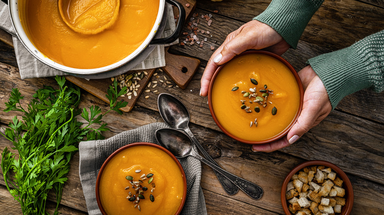 woman serving pumpkin soup