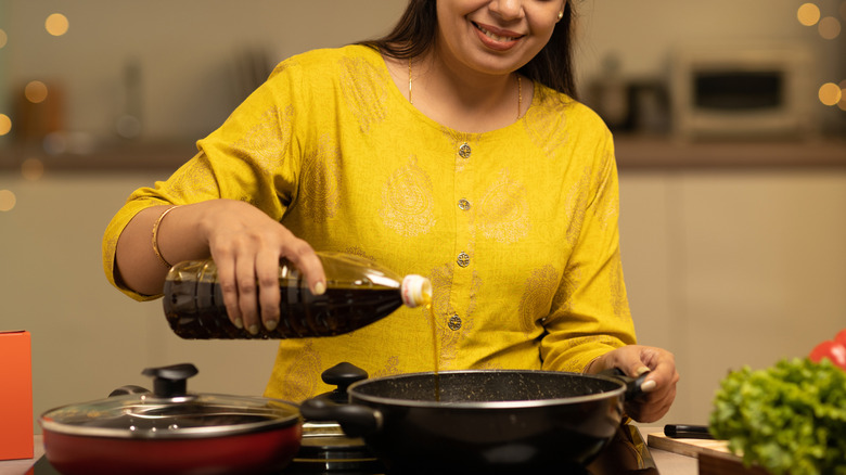 Indian woman cooking with oil