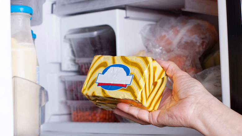 person placing butter in the freezer