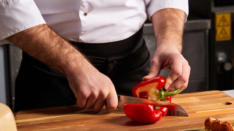 man cutting bell pepper