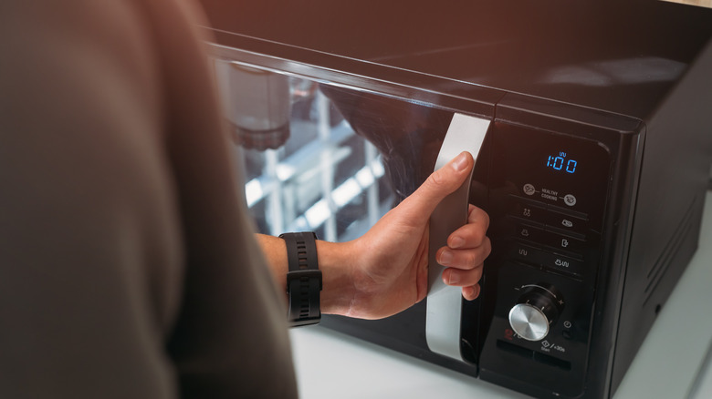 A man using a microwave.