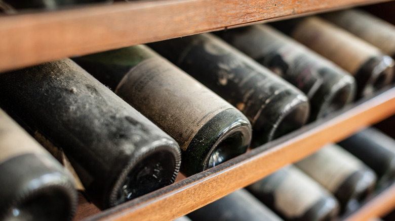 Aging red wine bottles on a rack