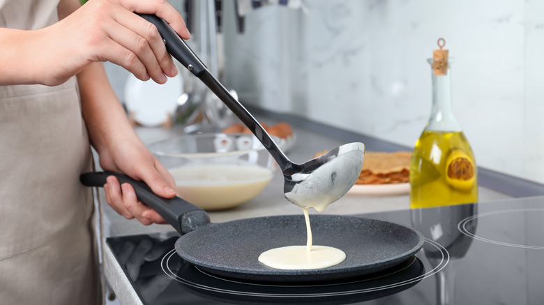 pouring pancake batter into pan