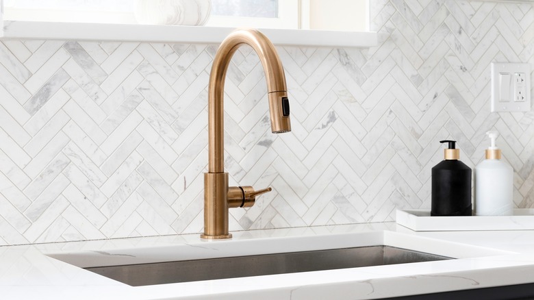 Kitchen sink with gold faucet