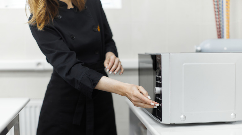 woman operating microwave