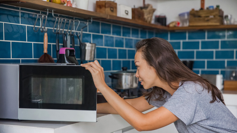 woman opening microwave