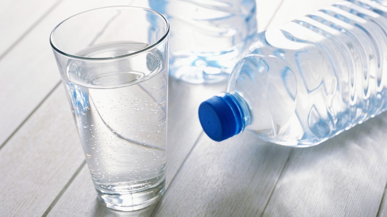 A pint glass next to a plastic water bottle