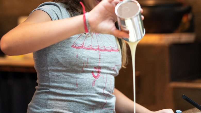 woman pouring evaporated milk